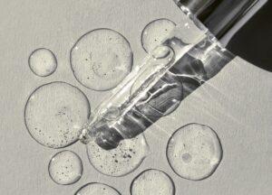 Glass dropper dispensing clear serum droplets