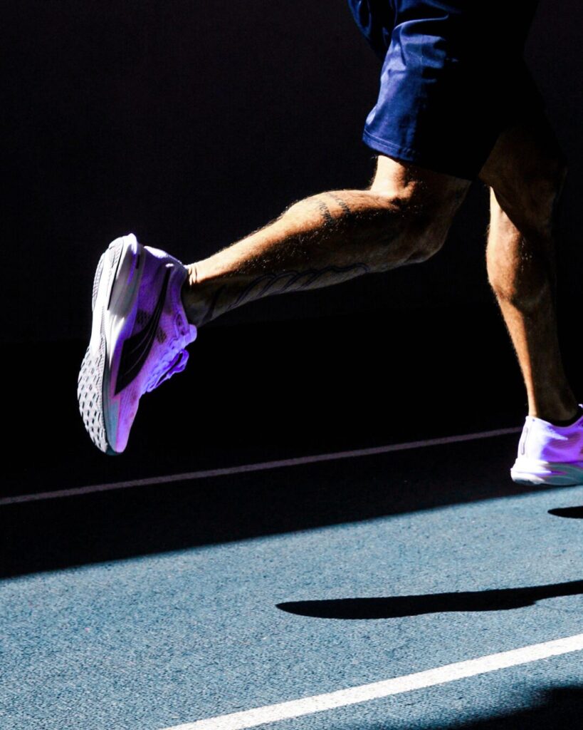 Close-up of runner's legs mid-stride on track